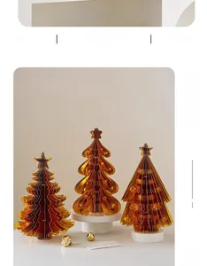 Detailed view of amber acrylic origami Christmas trees on a white display base