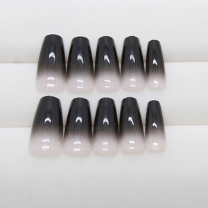 Minimalist black ombre coffin press-on nails with a glossy finish on white display tray
