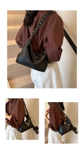 Detail of black faux leather tote with chain strap and tassel zipper in street scene