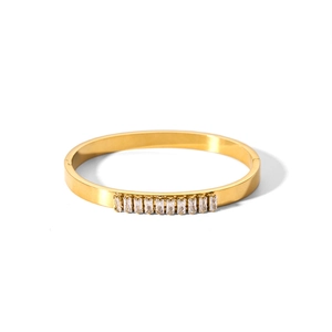 Gold plated titanium steel bangle with rectangular zirconia stones on white background