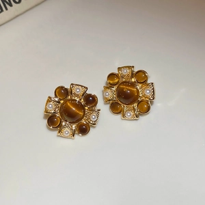 Detail view of vintage flower stud earrings with golden base and brown gems