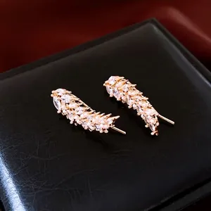Elegant gold leaf earrings with marquise zircon and pearls on a premium black display