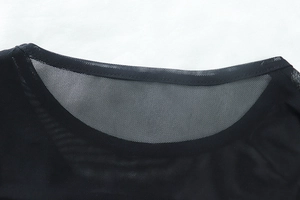 Detail of the reinforced round neckline and sheer black mesh fabric of the long sleeve dress