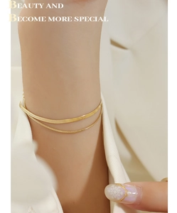 Double-layered gold blade chain bracelet in titanium steel worn on a female wrist