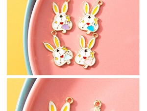 Nahaufnahme von bunten Kaninchenanhängern für DIY-Schmuck in einer rosa Schale