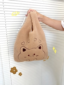 Detail of cute pig embroidery and heart patterns on the brown plush fleece wrist bag