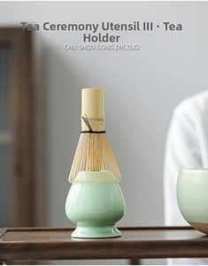 Detailed view of a handmade bamboo matcha whisk on a green ceramic holder stand