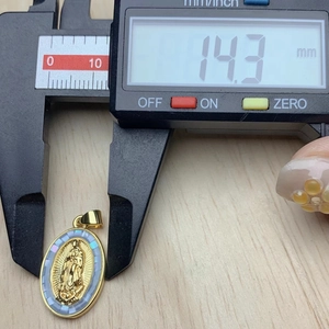 Oval Guadalupe pendant measurement showing 14.3mm width with digital caliper