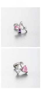Macro detail of cherry and butterfly earrings with pink heart zircon and silver steel
