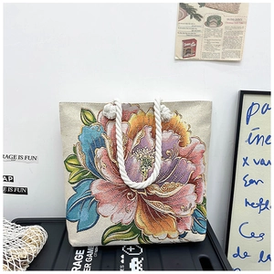 Detailed macro view of vibrant peony embroidery and durable white canvas tote texture