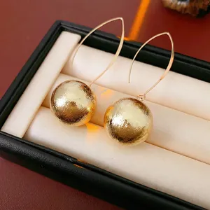 Boucles d'oreilles boules dorées minimalistes avec longs crochets et fini brossé
