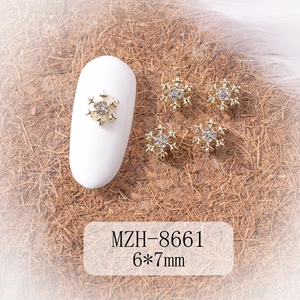 Macro view of gold alloy snowflake nail charms with rhinestones sized 6x7mm for DIY manicure