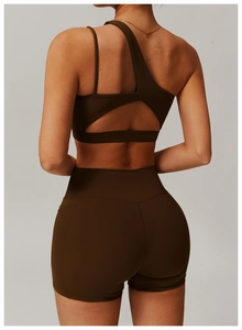 Close-up of deep brown one-shoulder sports bra and high-waisted shorts on model back