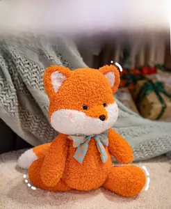 Detail of cute orange plush fox doll in sitting split pose with checkered bowtie