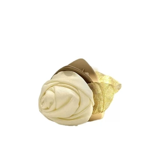 Detail view of a white camellia hair claw with golden mesh fabric and elegant floral accents