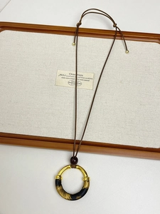 Detail of adjustable long necklace with leopard print fabric and golden metal rings