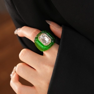 Détail d'une bague vintage en résine émeraude avec pierre carrée et accents diamantés