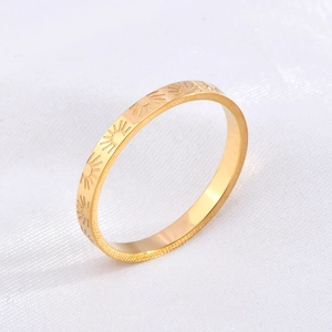 Macro detail of sunburst pattern engraving on polished 18k gold-plated thin steel ring