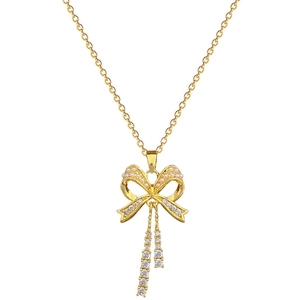 Elegant gold bow necklace with white pearl and sparkling zircon tassels on white background