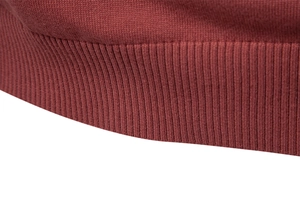 Gros plan sur l'ourlet côtelé et la maille de coton de ce pull col rond bordeaux