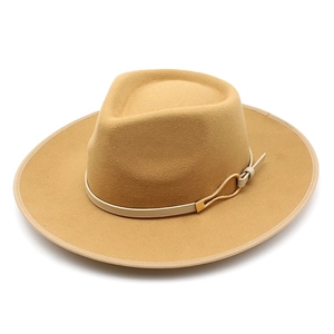 Detail of camel wool felt fedora featuring a beige leather band and gold metal buckle