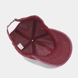 Detail of burgundy cotton baseball cap interior showing sweatband and metal buckle strap