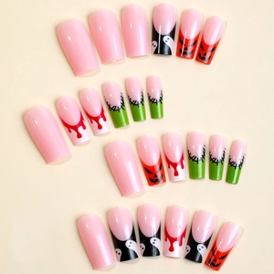 Halloween press-on nails featuring long coffin shapes with ghost and pumpkin designs