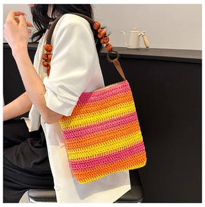 Detailed close-up of rainbow straw woven bag with pink gradient and wooden beads