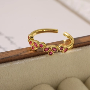 Elegant gold-plated open ring with red marquise zircon stones on a wooden jewelry box