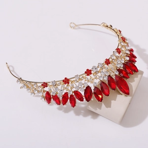 Macro detail of golden alloy bridal crown with marquise-cut red gems and crystals