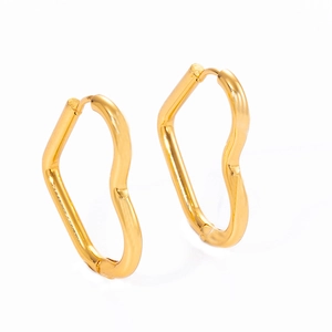 Close-up of irregular wave-shaped gold heart earrings with polished metallic texture