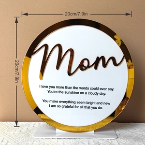 Macro view of Mother's Day round acrylic ornament with gold Mom lettering and base