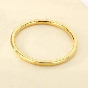 Detailed view of polished 18k gold plated 6mm hollow stainless steel ring on silk background
