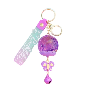 Süßer lila Acryl-Schlüsselanhänger mit Treibsand und rosa Silikonarmband mit Glocke