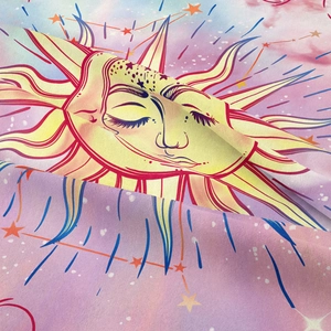 Macro detail of sun and star print on soft purple celestial tapestry fabric texture