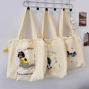Detailed close-up of cute cartoon dog patterns on beige canvas tote bags with drawstring