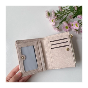 Detail view of pink PU leather bi-fold wallet featuring card slots and clear ID window