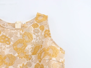 Detail eines beigen ärmellosen Oberteils mit goldenem Jacquard und Schulter-Reißverschluss