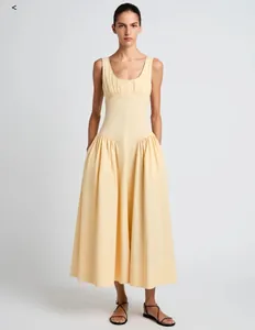Robe longue sans manches jaune pâle avec taille haute et jupe évasée à plis élégants