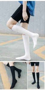 Outdoor shot of breathable cotton knee-high socks in black and white minimalist colors