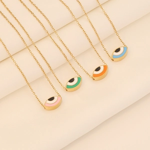 Detail of five gold stainless steel necklaces with colorful enamel evil eye pendants