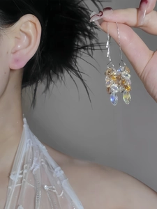 Macro detail of long tassel earrings with champagne glass crystals and silver needles