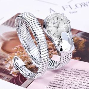 Close-up of silver snake-shaped ladies watch with diamond dial on a floral magazine