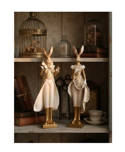 Close-up of Victorian resin rabbit figurines with gold floral relief and matte finish