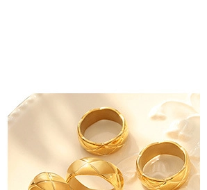 Detail of golden rings with quilted texture design on light background