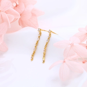 Detailed view of elegant gold S925 silver chain earrings with zircons on floral background