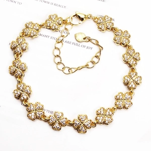 Detail of golden four-leaf clover bracelet featuring micro-paved white zircon stones