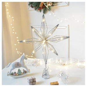 Silver glitter hollow star tree topper with warm LED lights on a white festive tabletop
