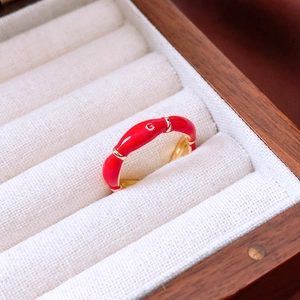 Detail of a 14K gold plated oval open ring with red enamel and golden G letter logo