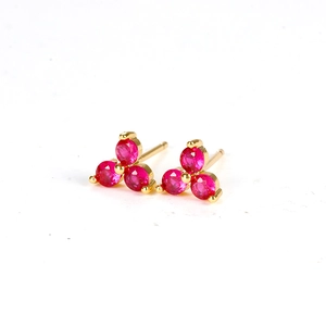 Chic gold four-leaf clover stud earrings with sparkling pink crystals on white background
